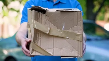 Person holding damaged freight box