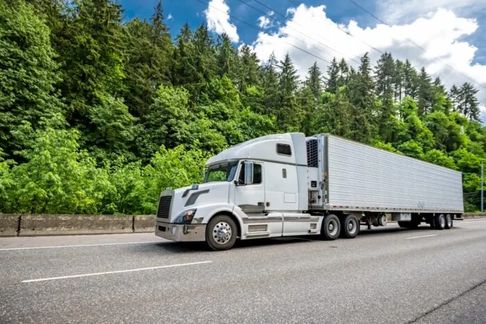 Industrial,Carrier,White,Big,Rig,Semi,Truck,Tractor,With,Extended white Truck driving on road